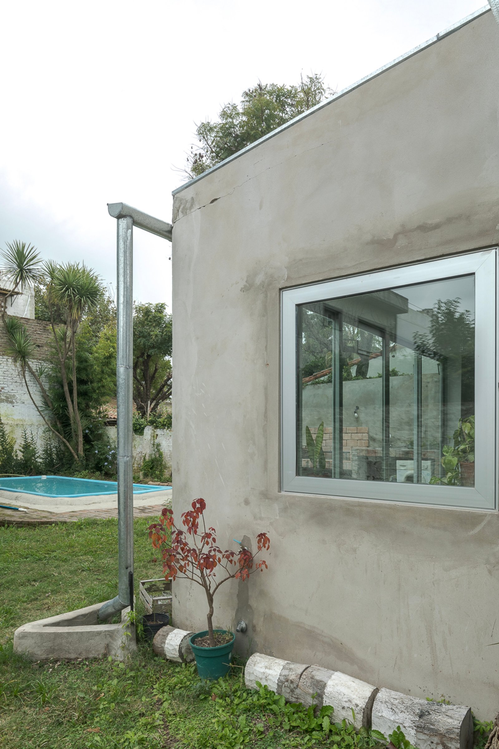 Fachada moderna con gran ventana y piscina exterior — proyecto Reforma Navarro, por Estudio YME, en B1648 Tigre
